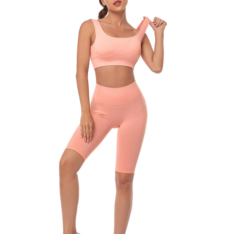 A stylish seamless yoga set for women, featuring leggings, a fitness bra, and a crop top in various colors including pink and black.