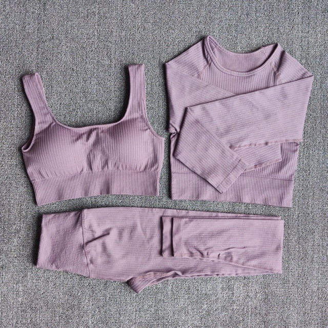 A stylish seamless yoga set for women, featuring leggings, a fitness bra, and a crop top in various colors including pink and black.