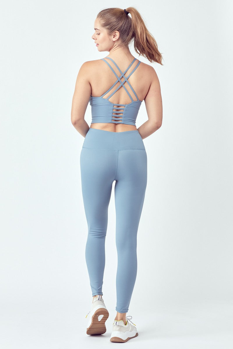 Woman in backless blue athletic wear.