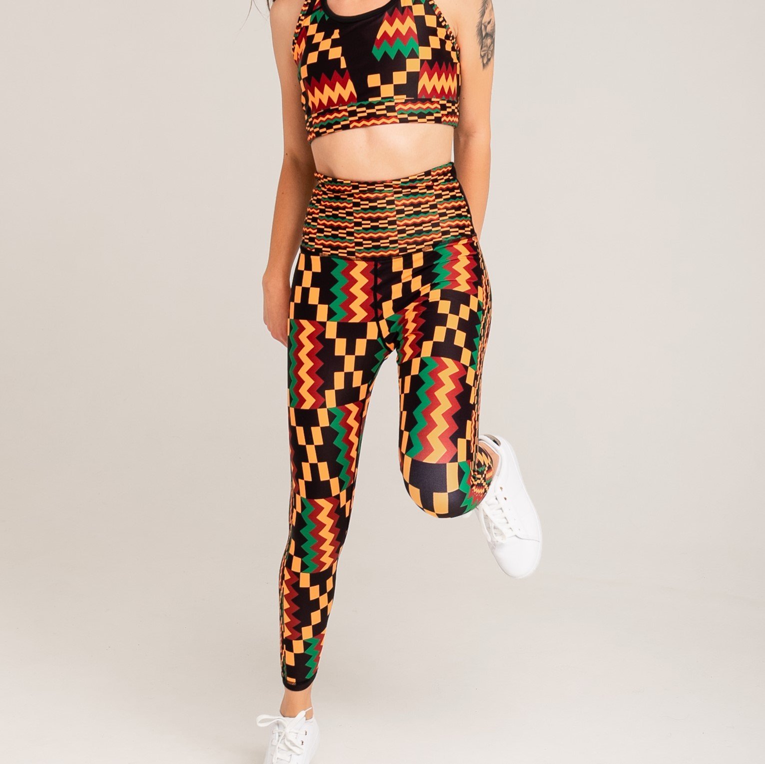 Kayentee Vibrant Leggings featuring bold geometric Kente cloth pattern in black, green, saffron, and flame colors, designed for comfort and performance.