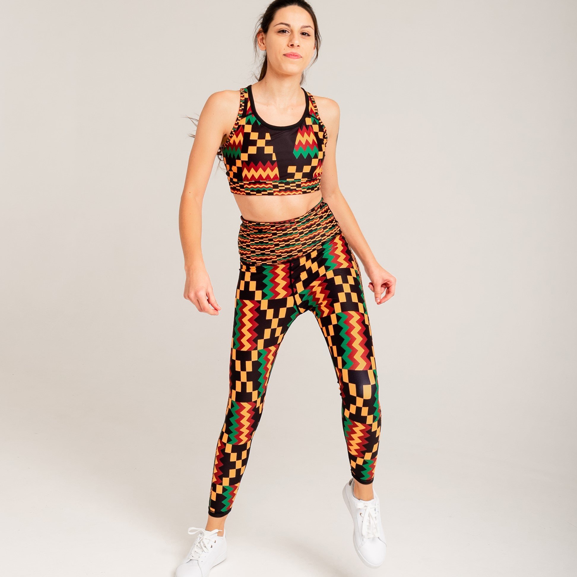 Kayentee Vibrant Leggings featuring bold geometric Kente cloth pattern in black, green, saffron, and flame colors, designed for comfort and performance.