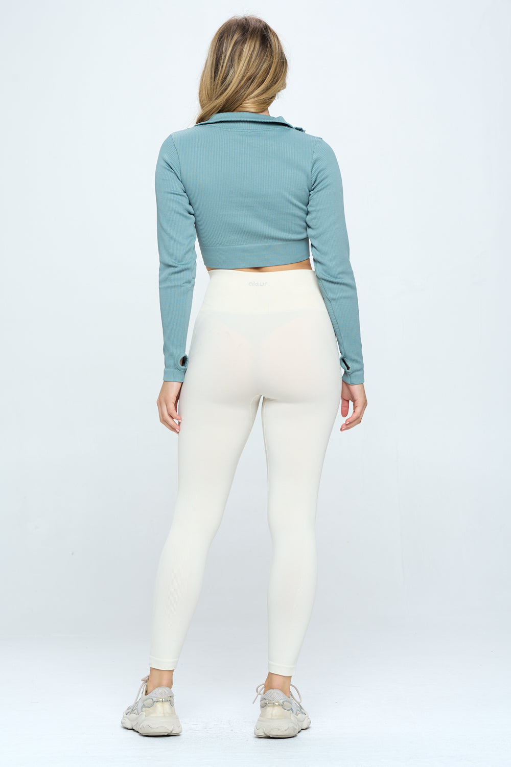 A stylish Seamless Half Zip Thumb Holes Crop Top in a stretchy knit material, featuring a high neckline and long sleeves, perfect for workouts.