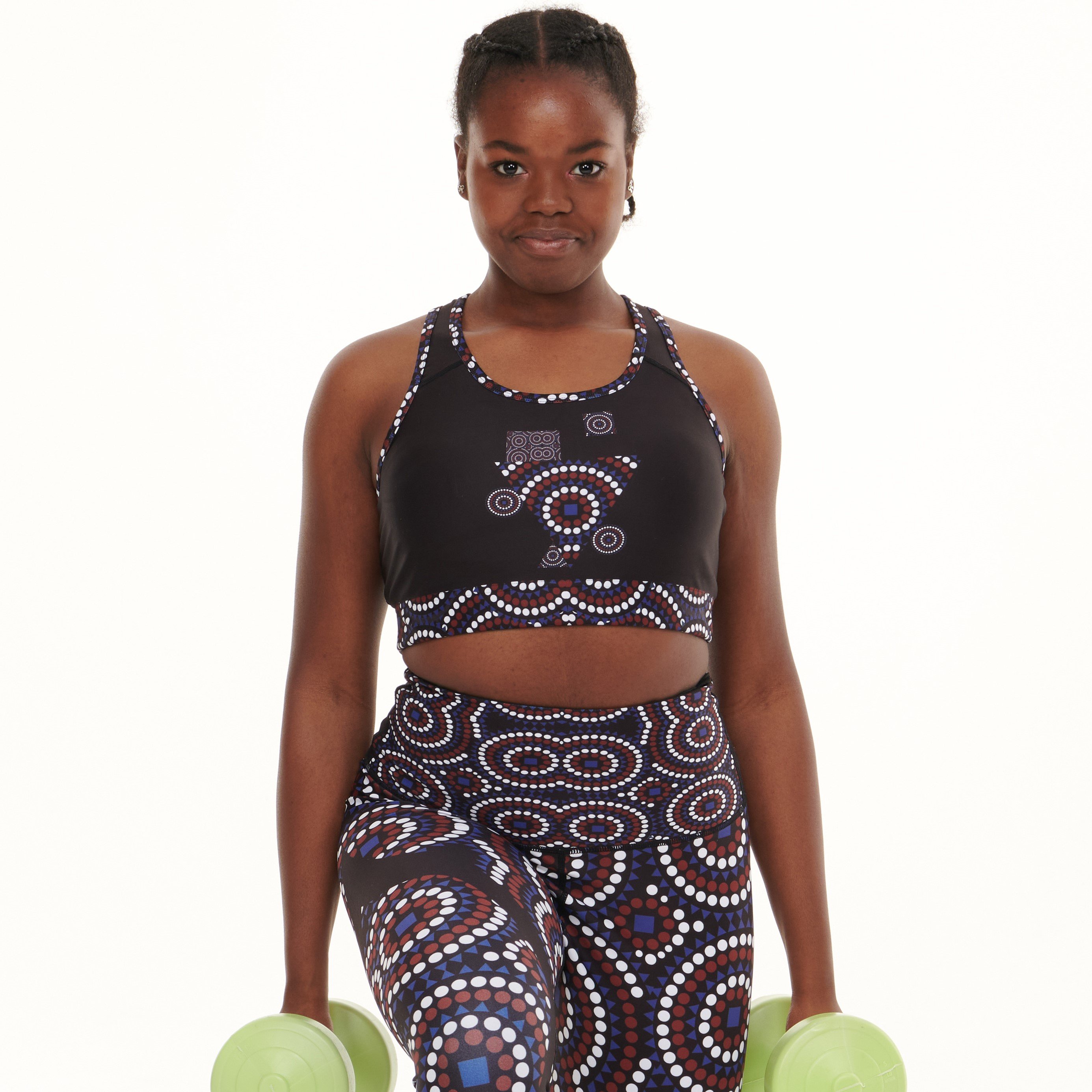 A stylish black sports bra featuring the TYNA Signature Print with vibrant colors including blue, burgundy, and white, designed for active women.