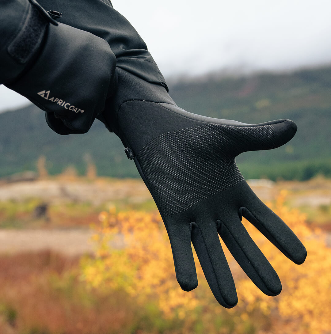 A pair of eco-friendly thermal gloves made from recycled polyester, showcasing their lightweight and stretchy design, perfect for outdoor activities.