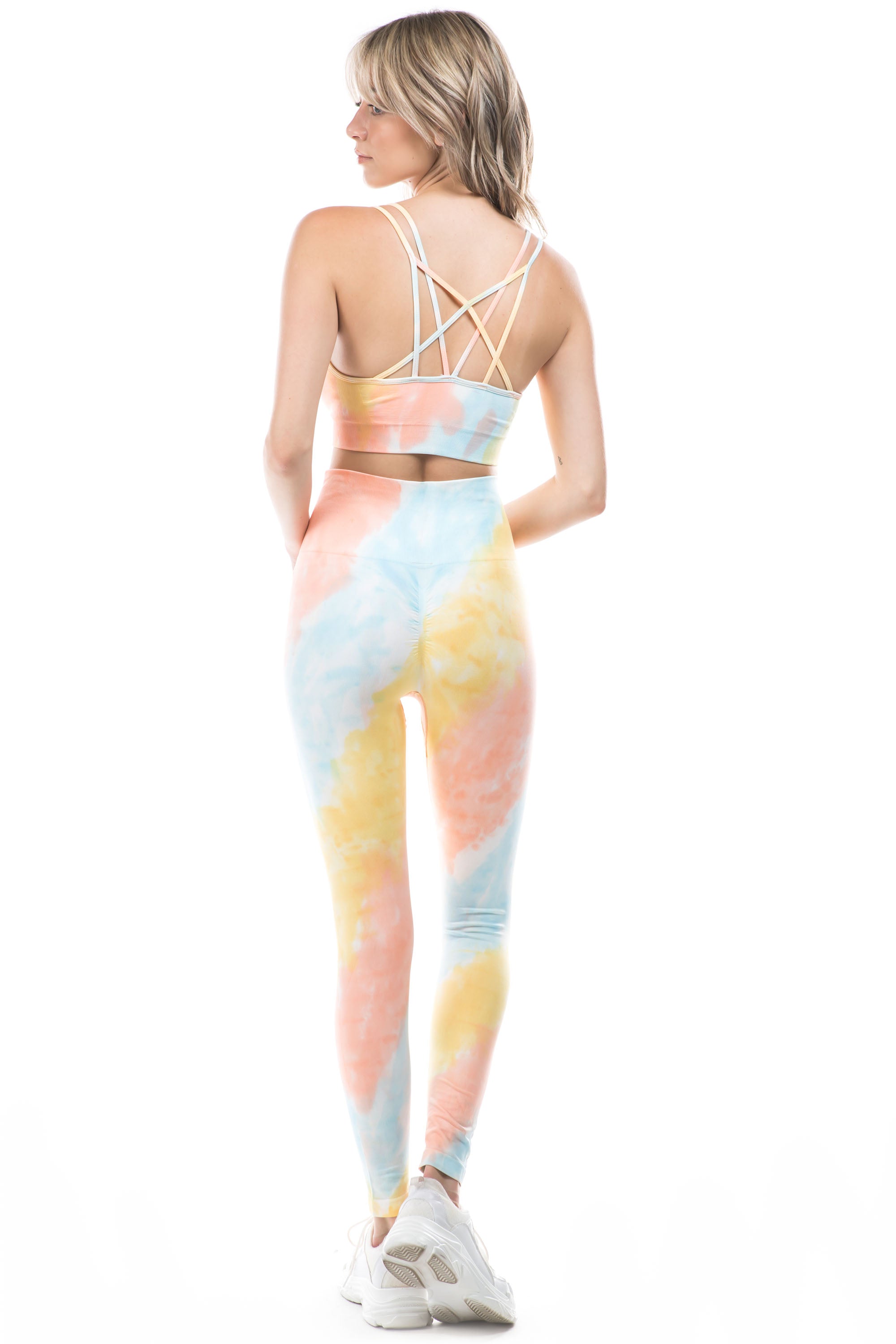 A vibrant peach tie-dye active set featuring a strappy back bra and high-waisted leggings, perfect for workouts and casual wear.