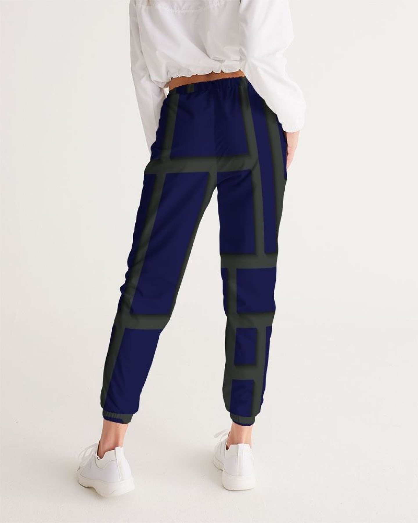 Womens track pants in blue and green geometric graphic, showcasing lightweight and water-resistant fabric with zip pockets.