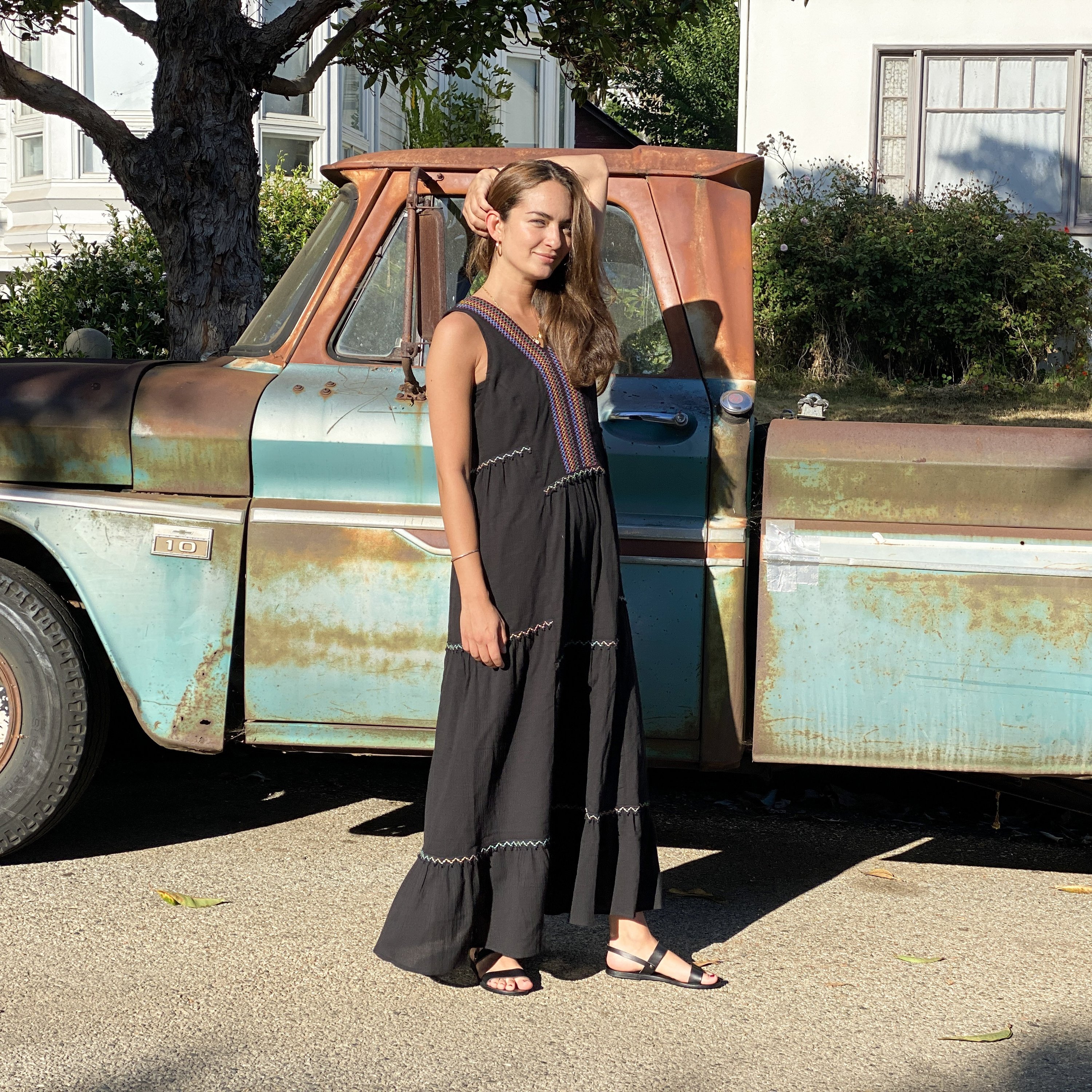 Black Amalfi Maxi Dress featuring colorful bohemian embroidery on breathable cotton fabric, with a tiered hem and loose fit.