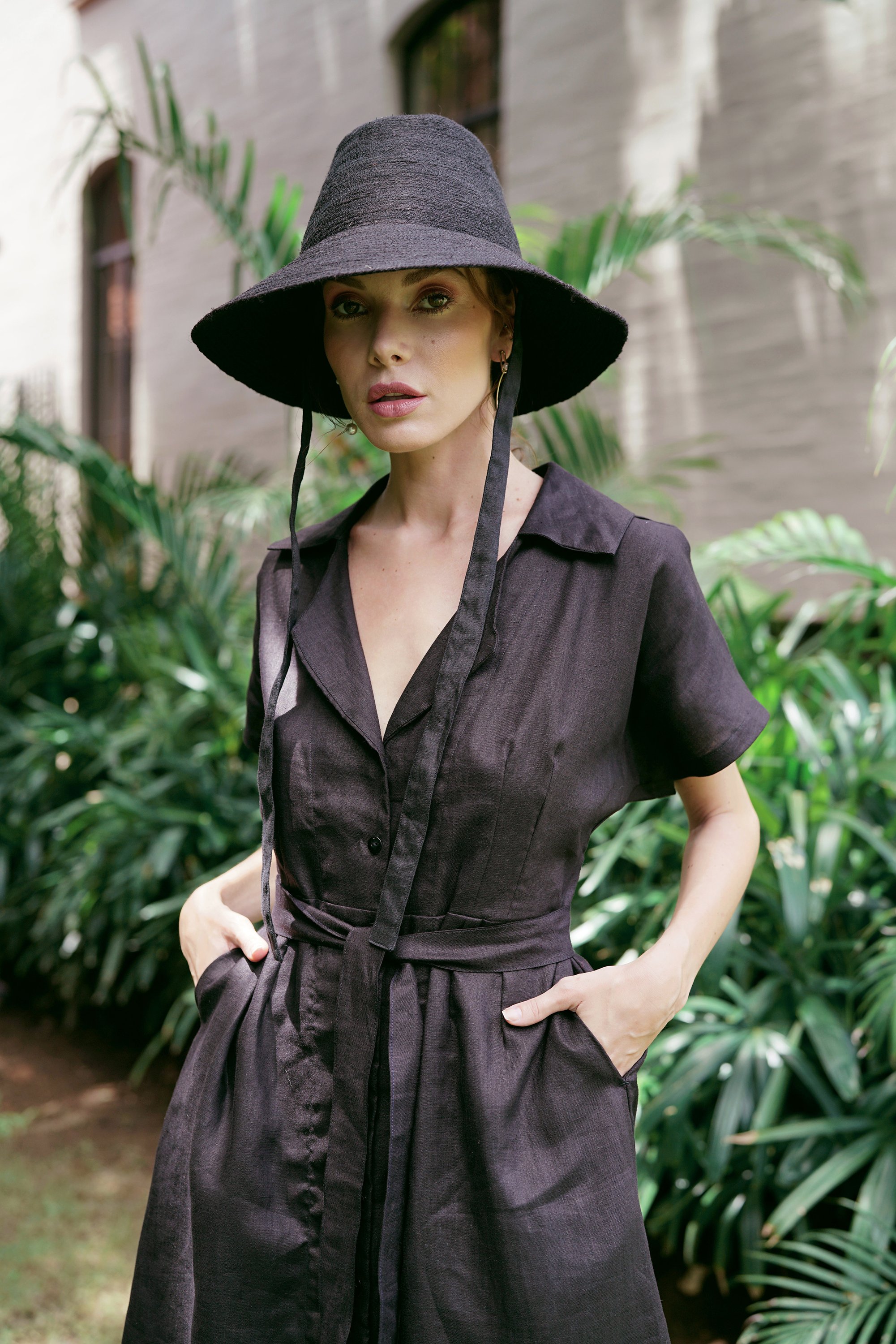 ARYA Safari Linen Midi Dress in Black, showcasing its elegant design, button-down closure, and spacious side pockets.