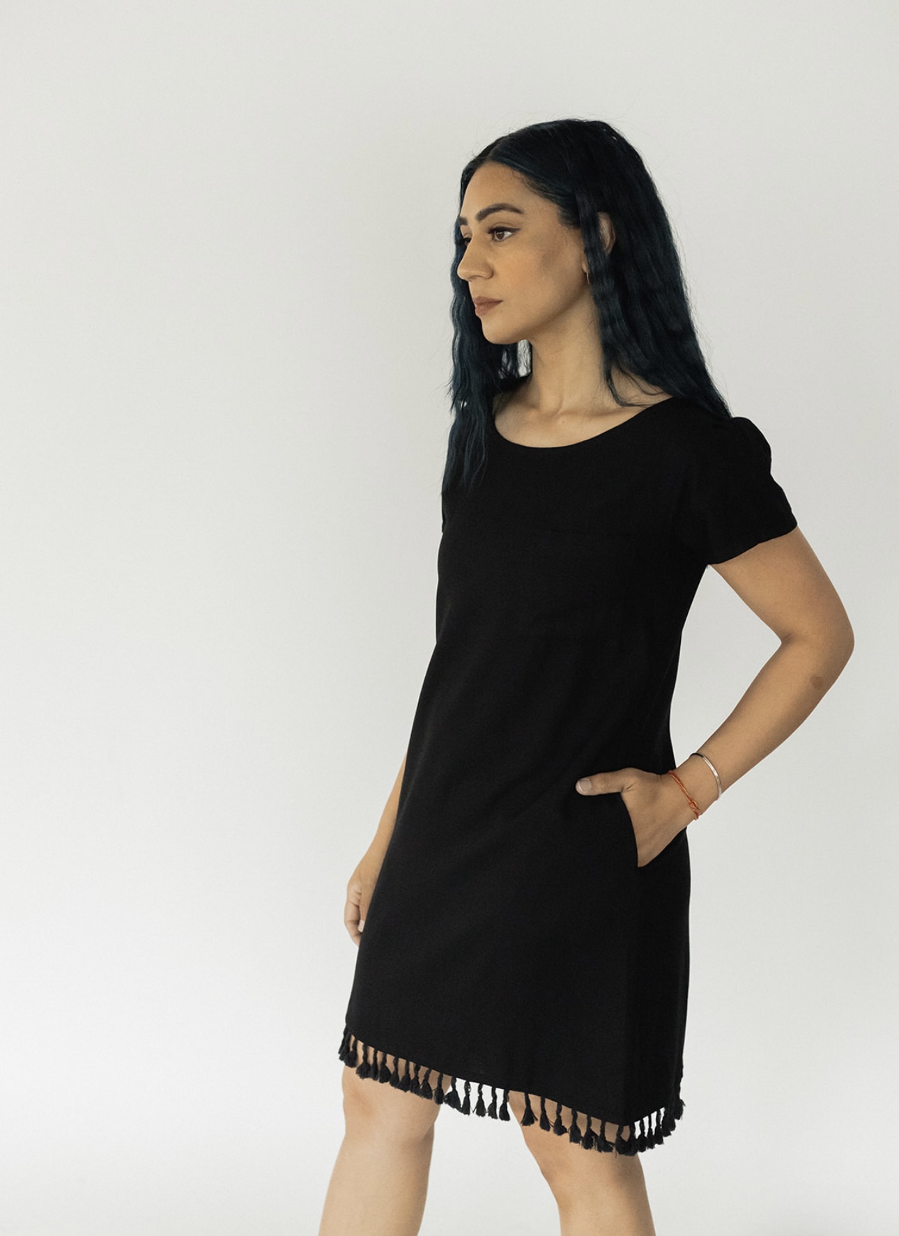 A stylish Beach T-Shirt Dress featuring a scoop neck, pleated short sleeves, side pockets, and a fringe hemline, perfect for summer outings.