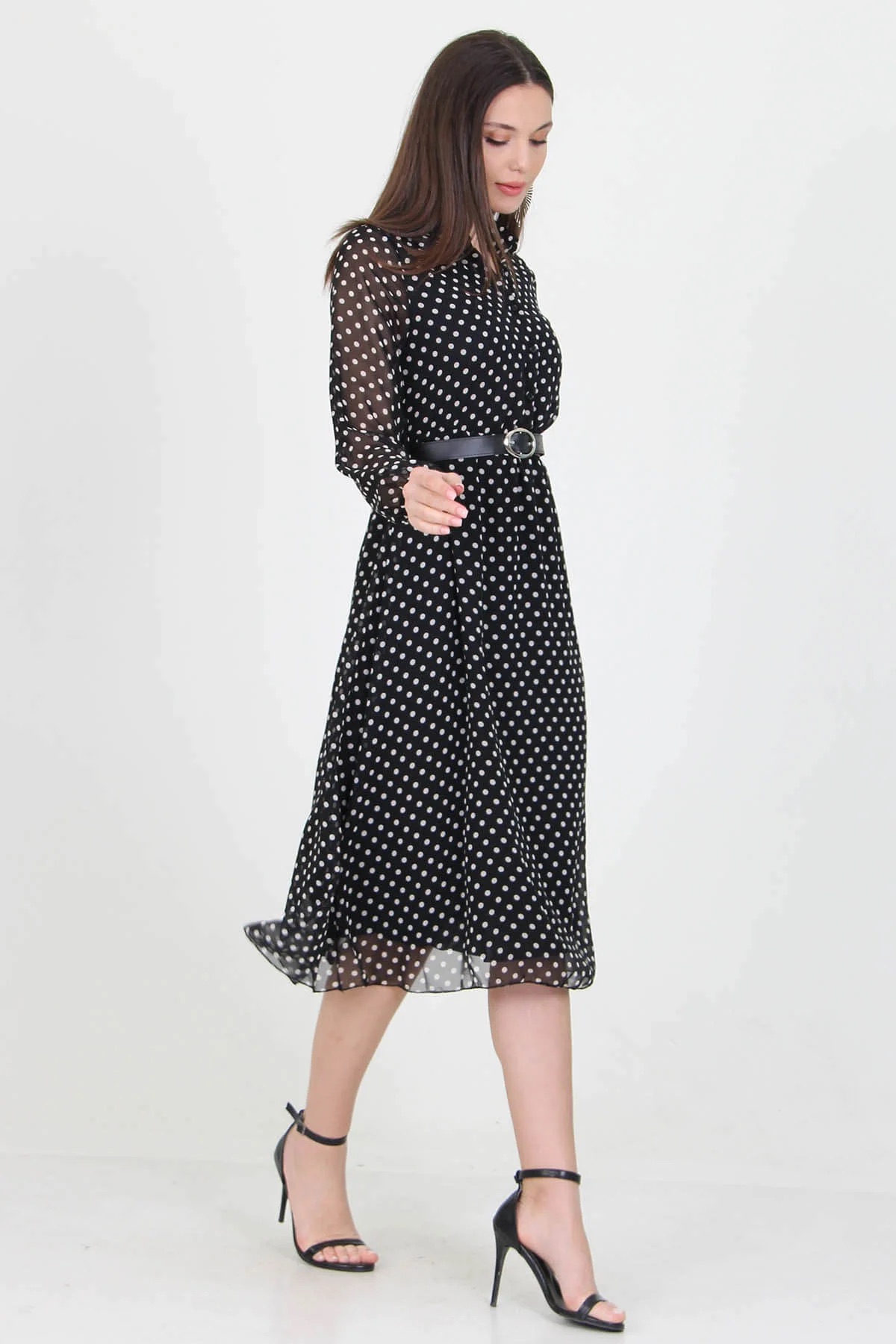 A stylish black polka dot dress hanging on a mannequin, showcasing its elegant design and playful pattern.