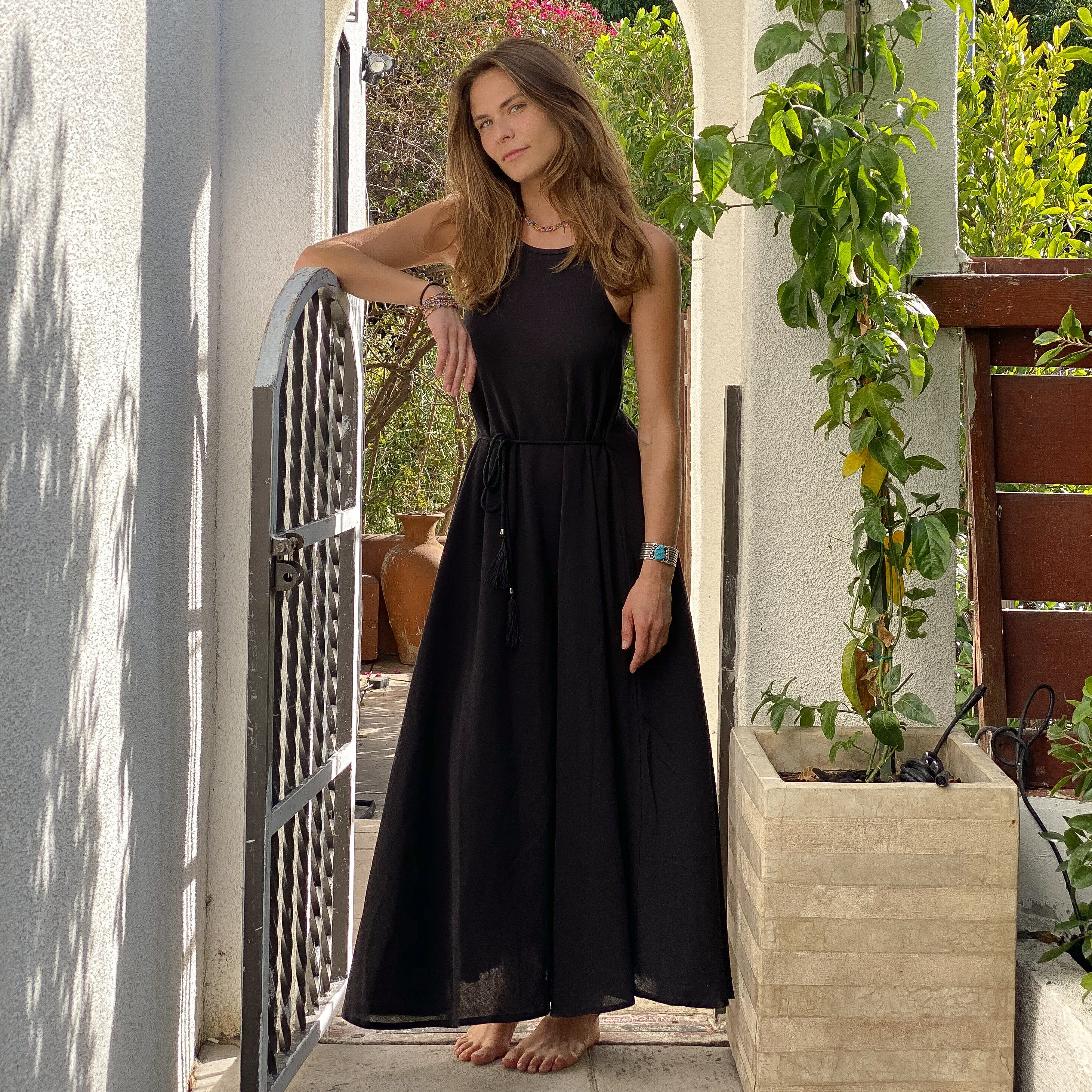 Callie Maxi Dress in black featuring narrow straps and tassel waist ties, perfect for summer outings.