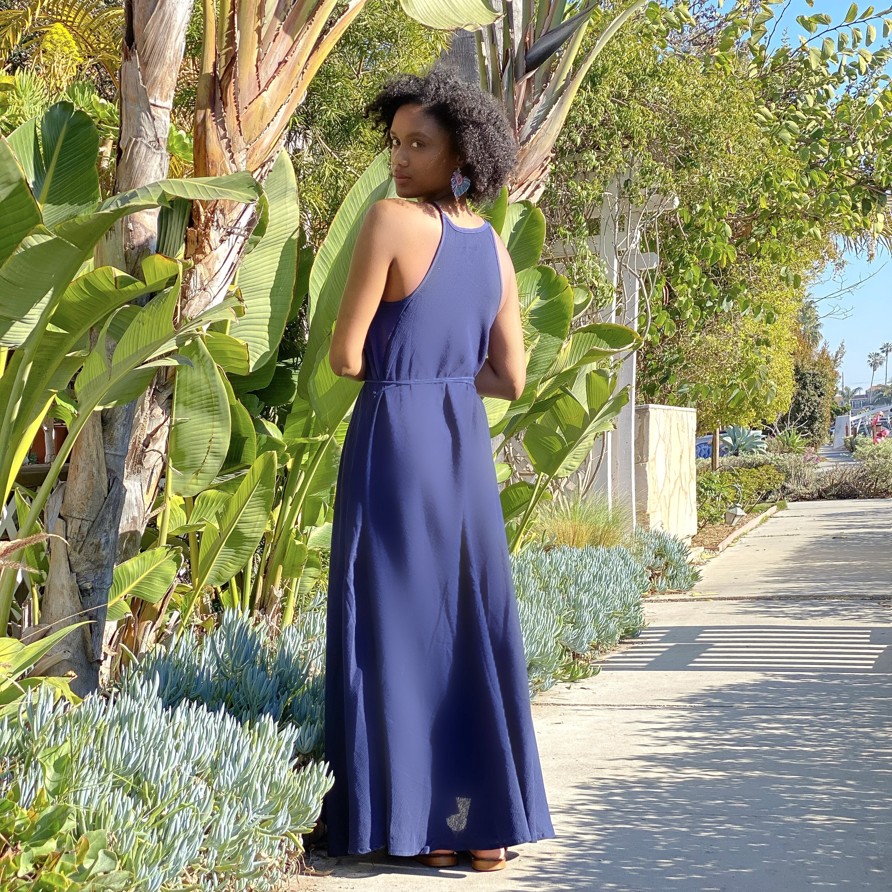 Callie Maxi Dress in black featuring narrow straps and tassel waist ties, perfect for summer outings.