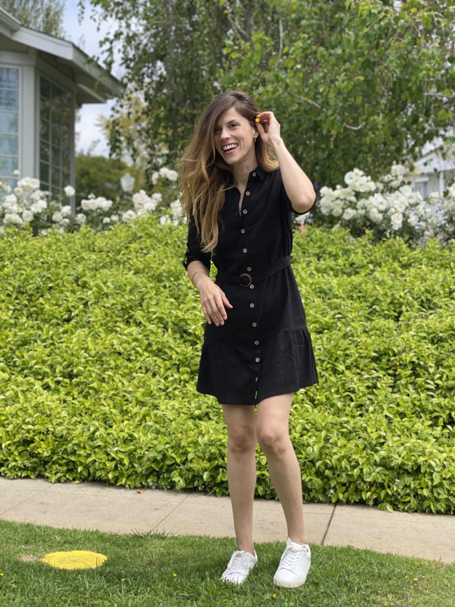 A stylish black cotton shirt dress with an O-ring belt and flared mini skirt, perfect for casual outings.