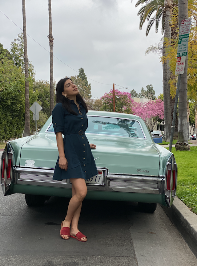 A stylish petrol-colored shirt dress with an O-ring belt, featuring a slightly loose fit and a flared mini skirt, perfect for summer outings.