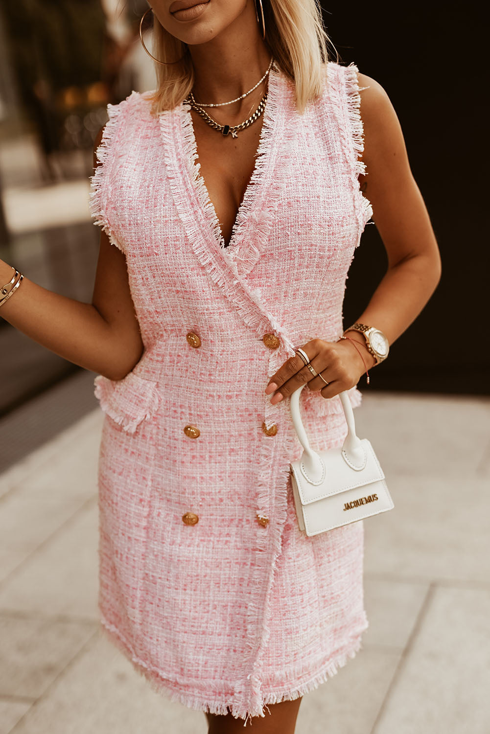 A stylish double breasted vest dress featuring a frayed edge design, flap pockets, and a deep V-neck, made from cozy tweed material.