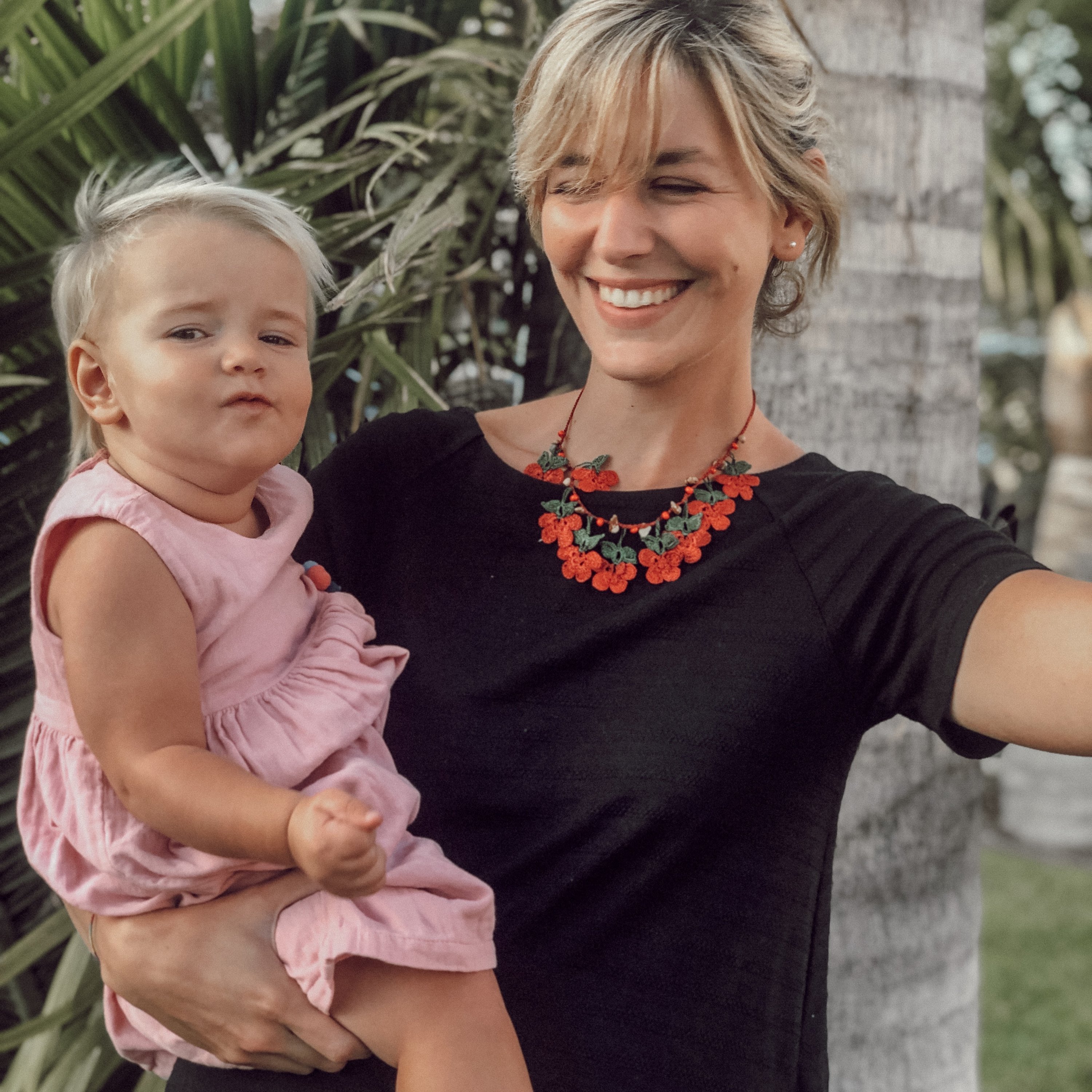 EGGUE Beaded Necklace featuring red floral embroidery and natural stones, elegantly displayed in a drawstring pouch.