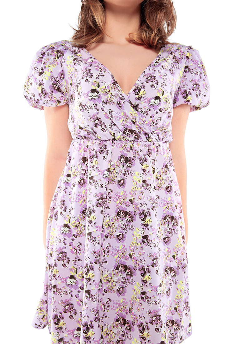 A stylish Floral Short Cut Out Dress featuring a wrap V neckline, short puffy sleeves, and a sexy cut-out back with tie-ups in light purple floral print.