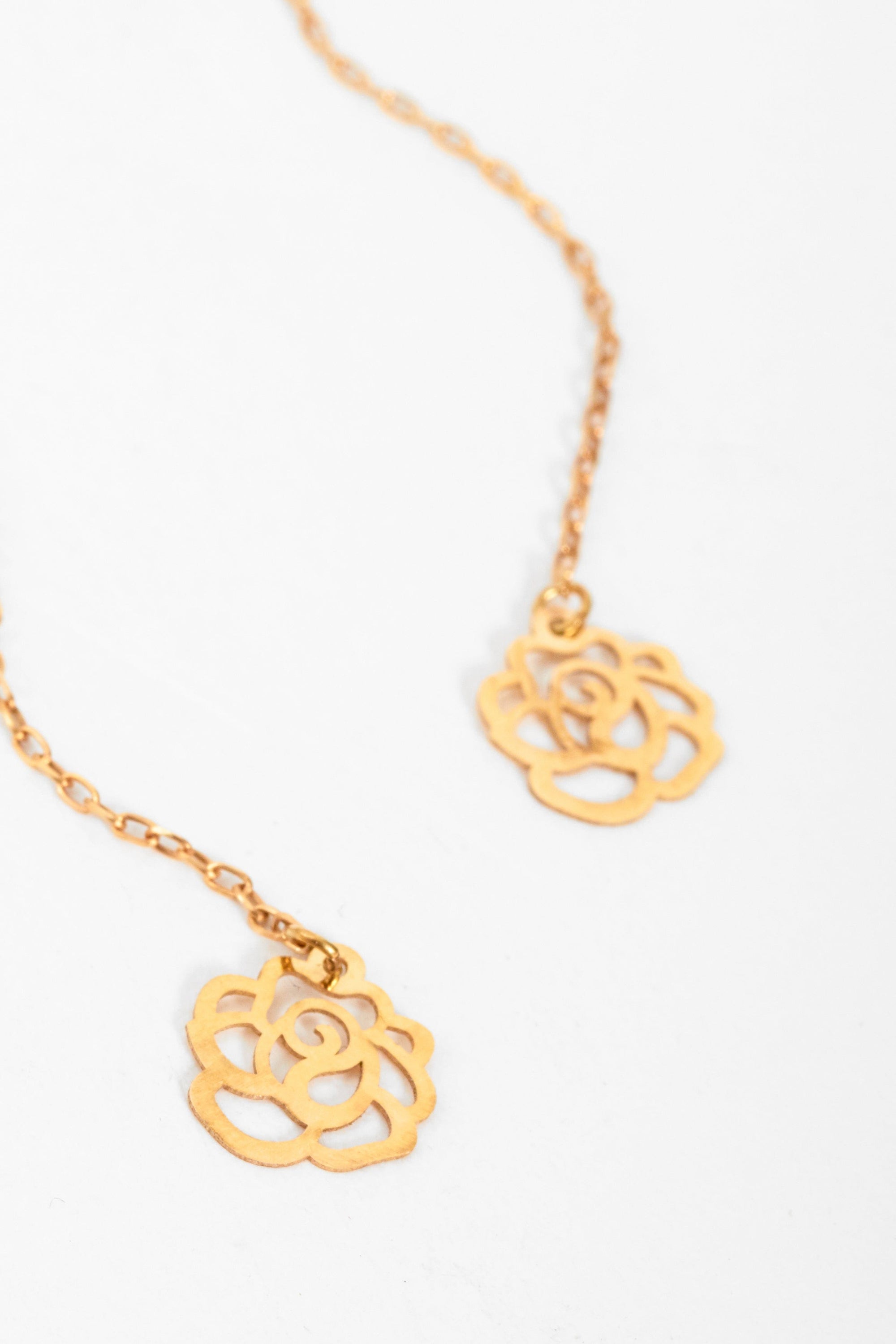 Elegant gold thread through earrings with flower design, handcrafted in 18K gold, showcasing intricate detailing.