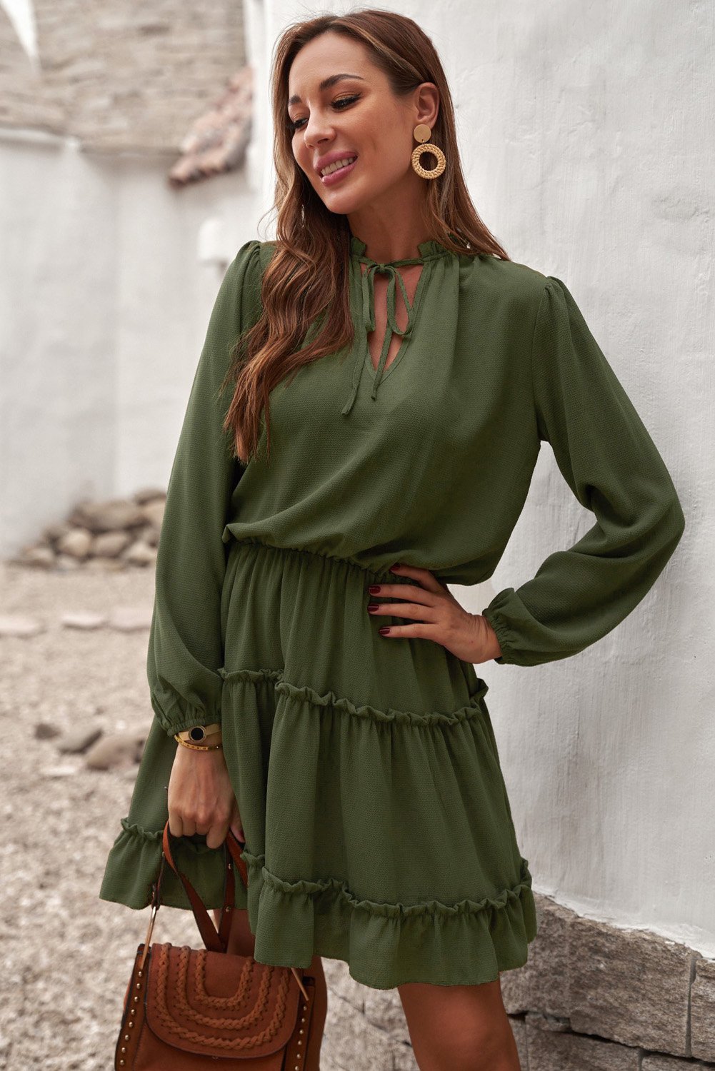 A stylish green V neck long sleeve mini dress with ruffles and a tiered design, perfect for elegant occasions.