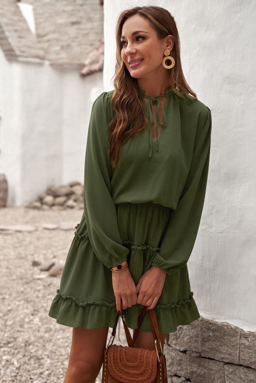 A stylish green V neck long sleeve mini dress with ruffles and a tiered design, perfect for elegant occasions.