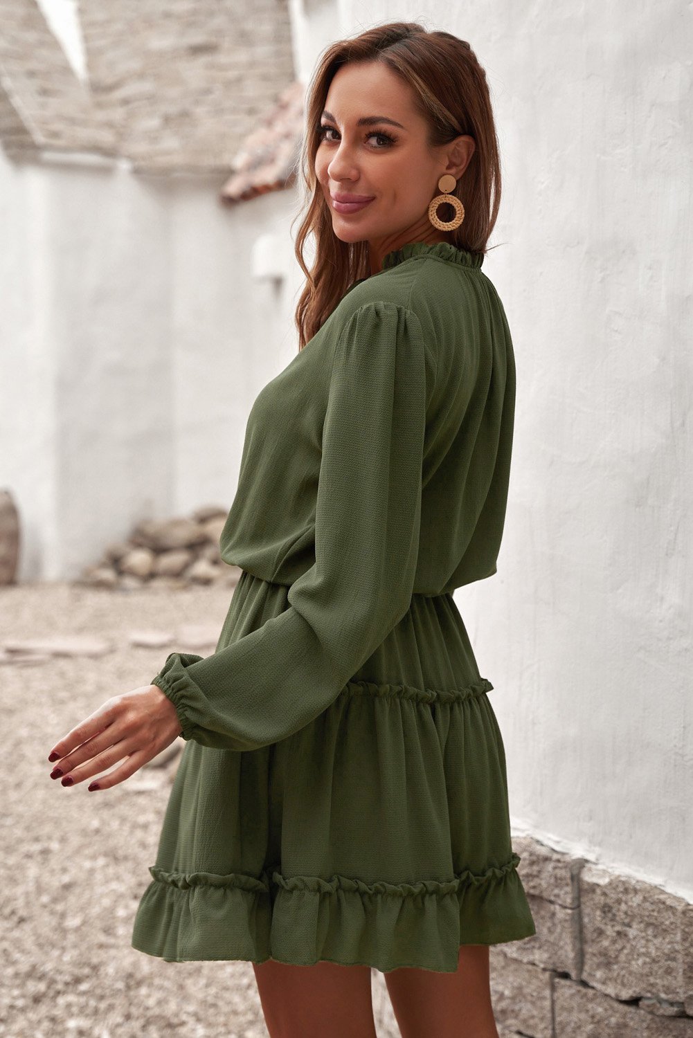 A stylish green V neck long sleeve mini dress with ruffles and a tiered design, perfect for elegant occasions.