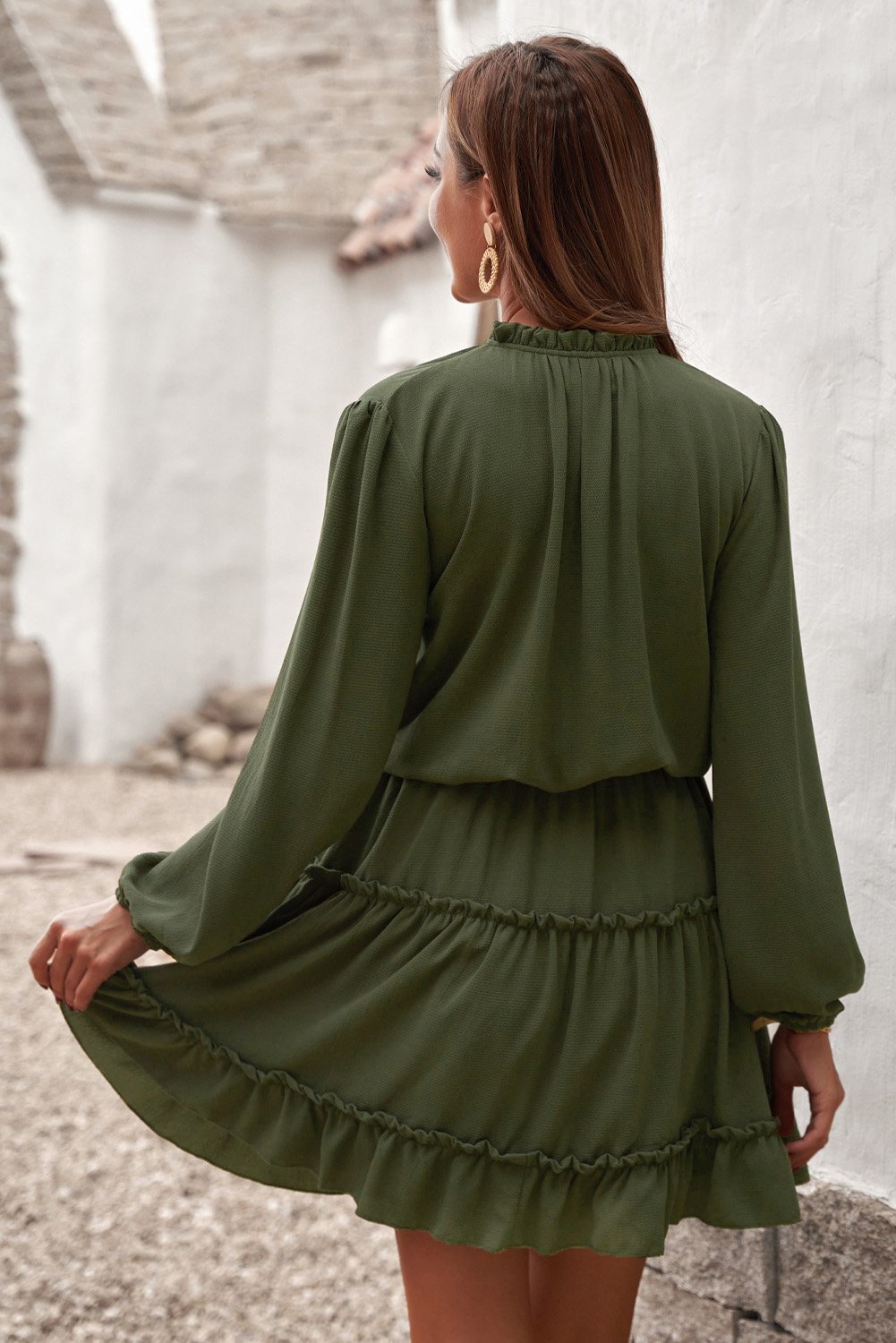 A stylish green V neck long sleeve mini dress with ruffles and a tiered design, perfect for elegant occasions.