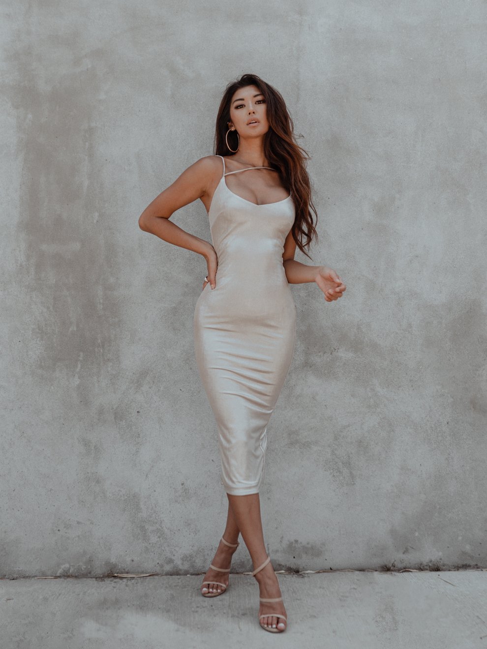 A stunning champagne bodycon dress with a plunging neckline and adjustable straps, featuring subtle shimmer for a glamorous look.