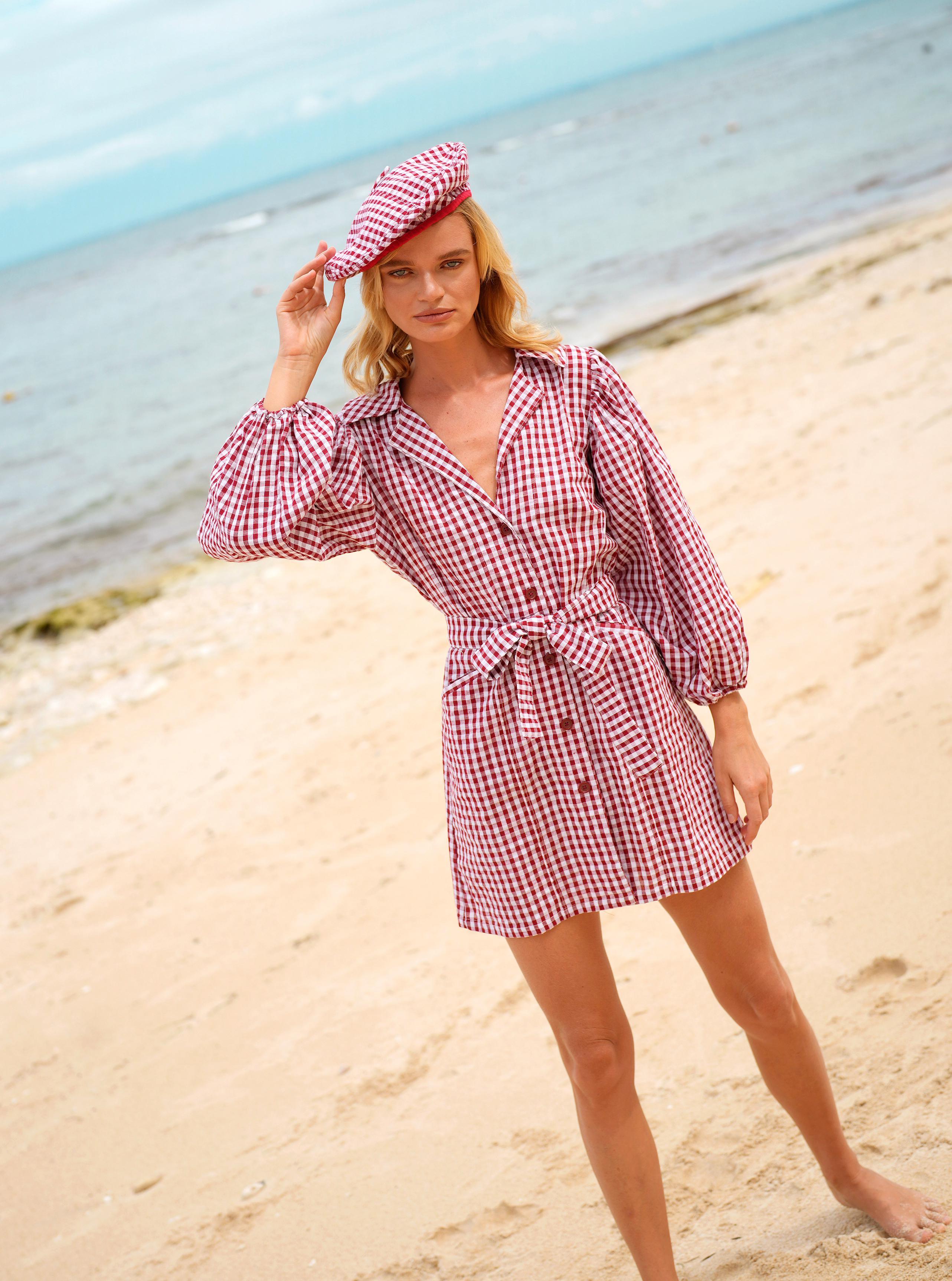 A stylish MEGHAN Mini Dress in Gingham Red featuring puff sleeves and a chic short skirt with bow detailing.