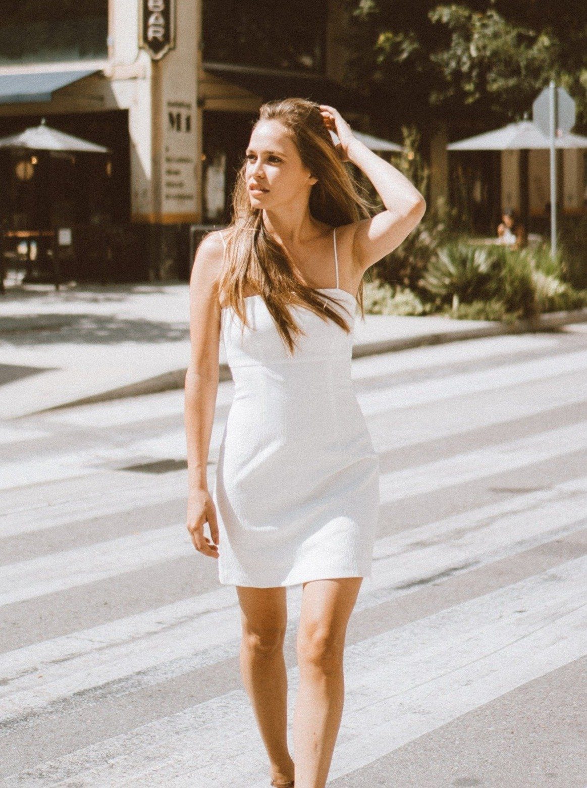 A stylish Melody White Mini Dress featuring a square neckline, spaghetti straps, and textured fabric, perfect for various occasions.