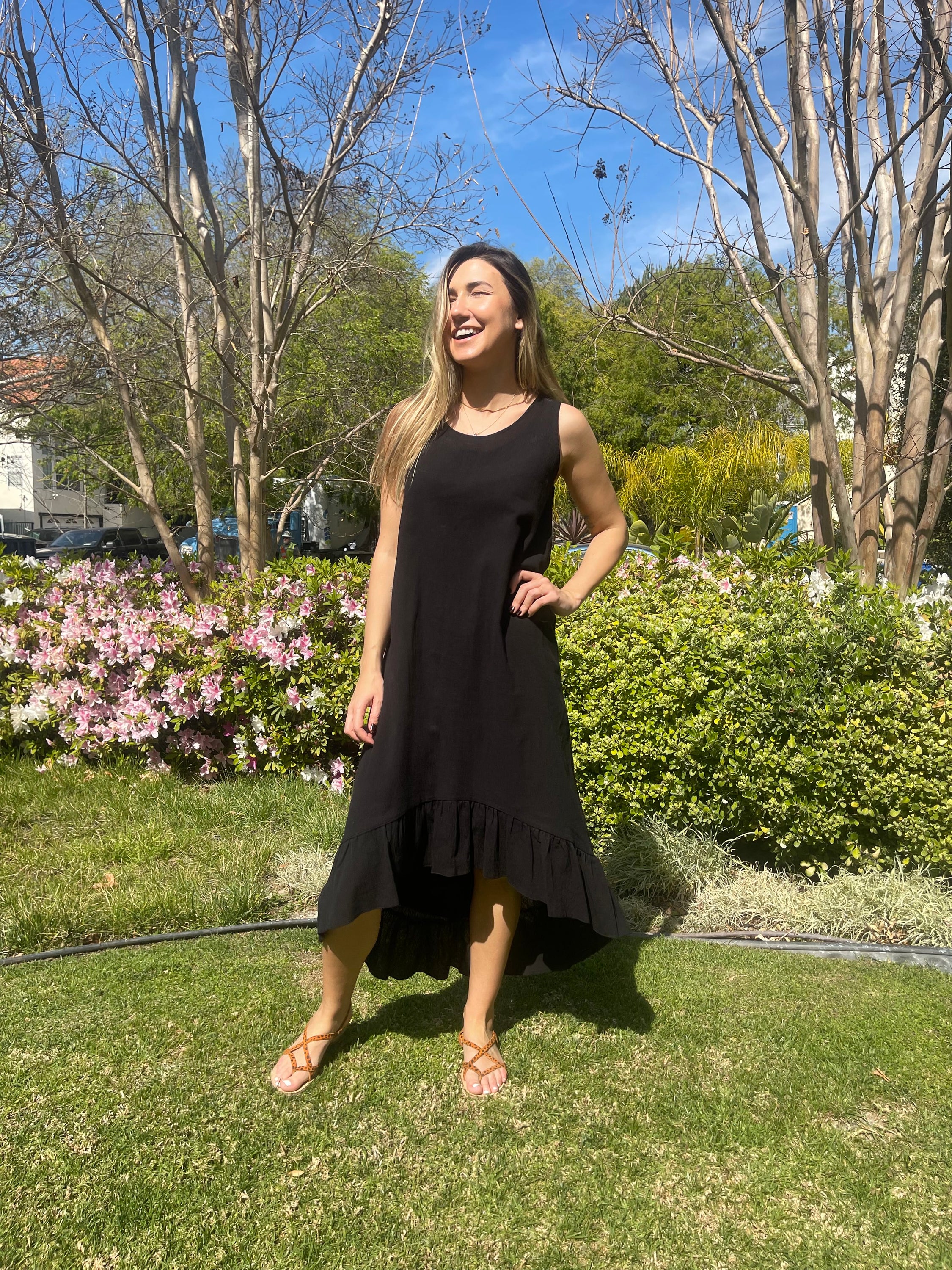 A stylish black maxi dress made from 100% Turkish cotton, featuring adjustable tie straps and a breezy silhouette, perfect for summer outings.