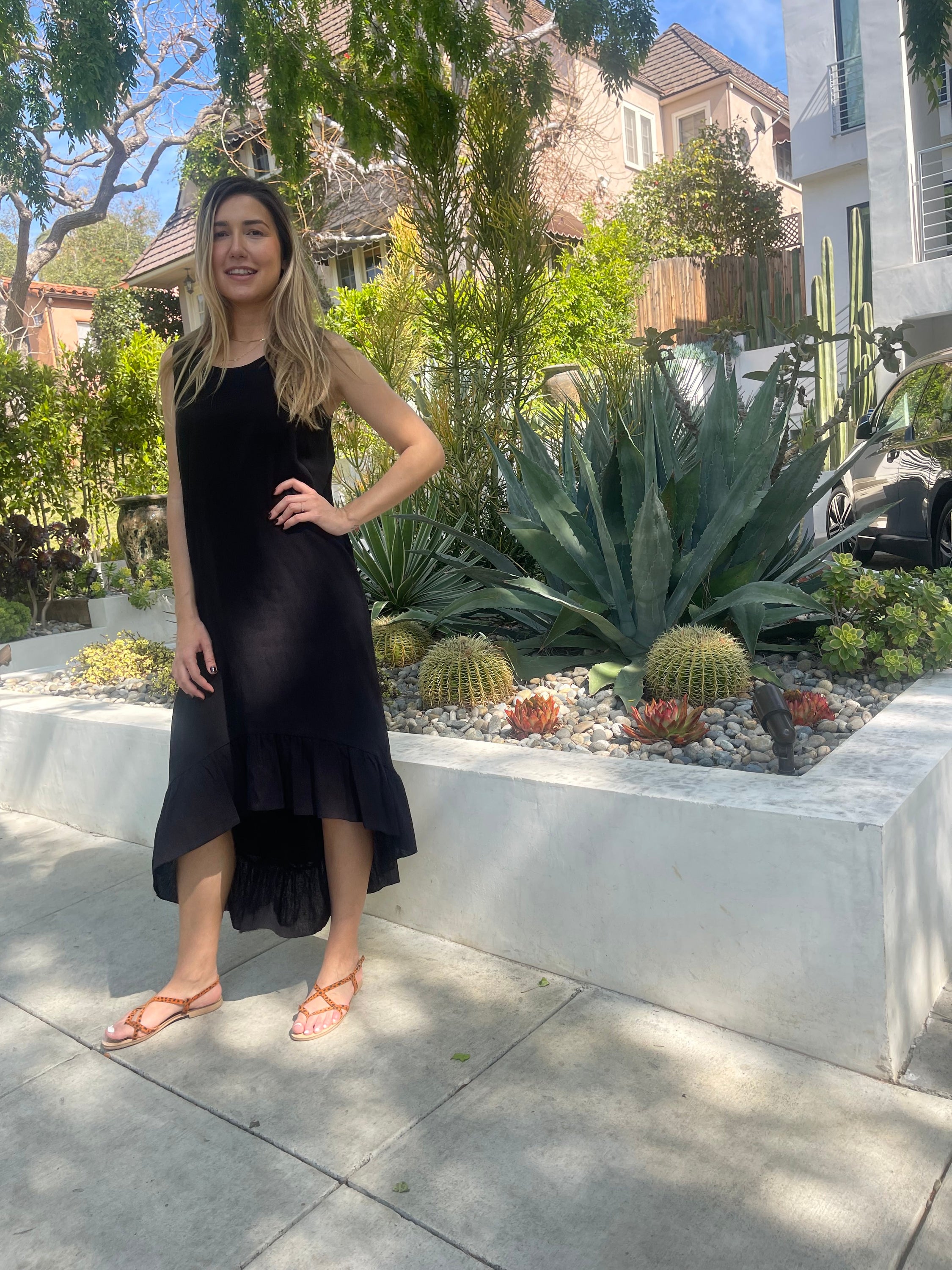 A stylish black maxi dress made from 100% Turkish cotton, featuring adjustable tie straps and a breezy silhouette, perfect for summer outings.