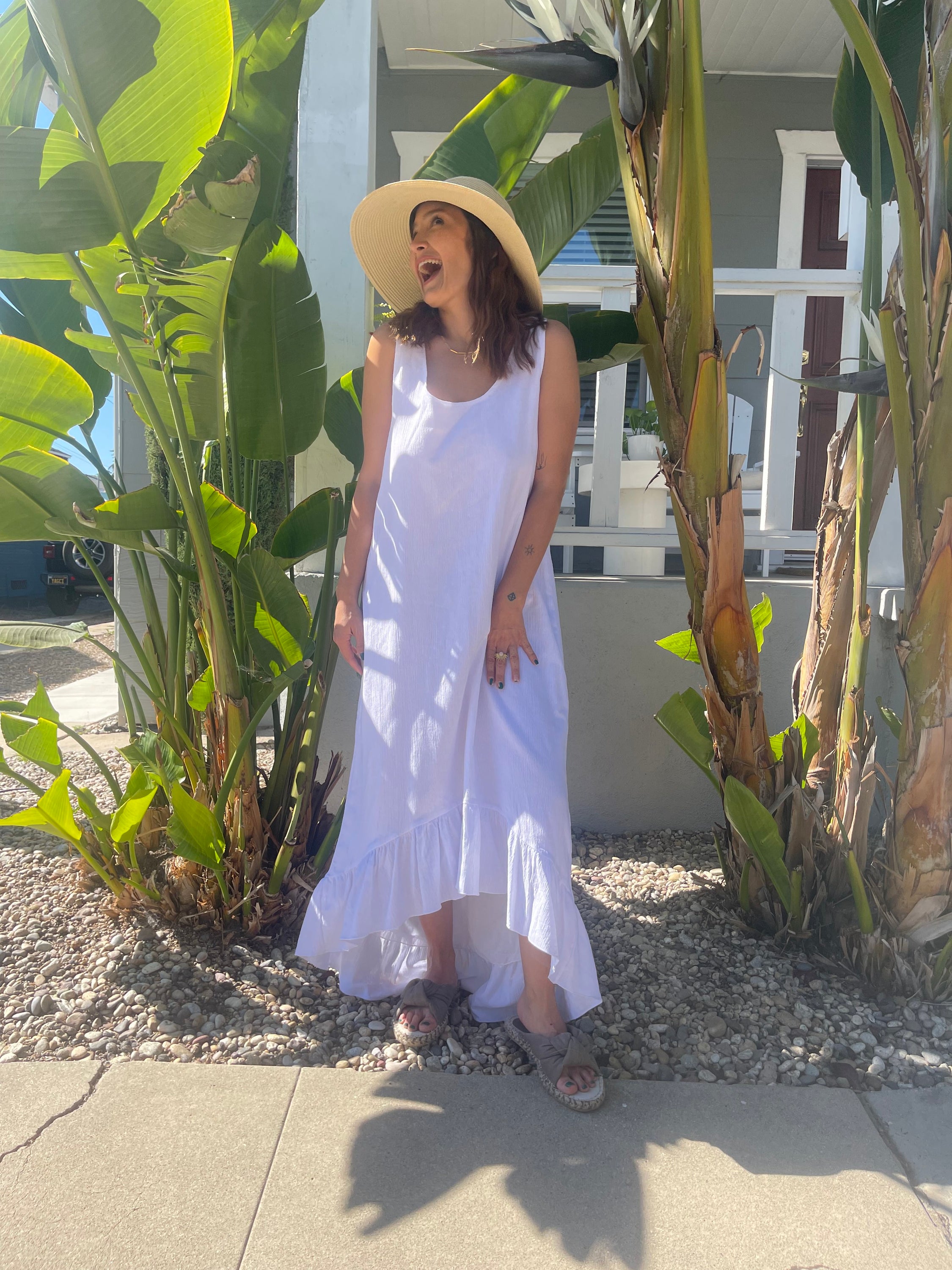 A stylish white maxi dress made from 100% Turkish cotton, featuring adjustable tie straps and a breezy silhouette, perfect for summer outings.