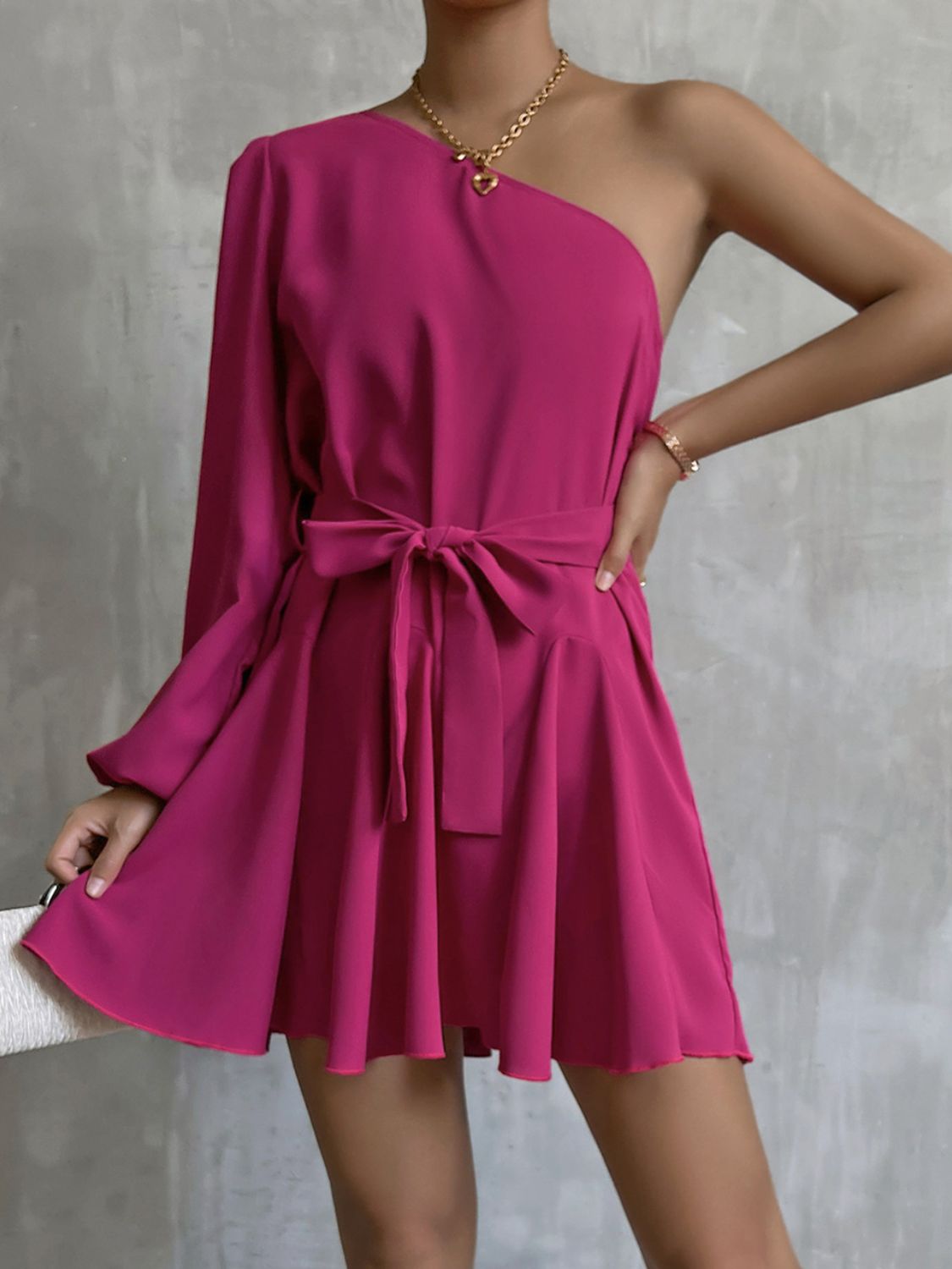 A stylish one-shoulder belted mini dress featuring puff long sleeves and a ruffle detail, perfect for cocktail events.