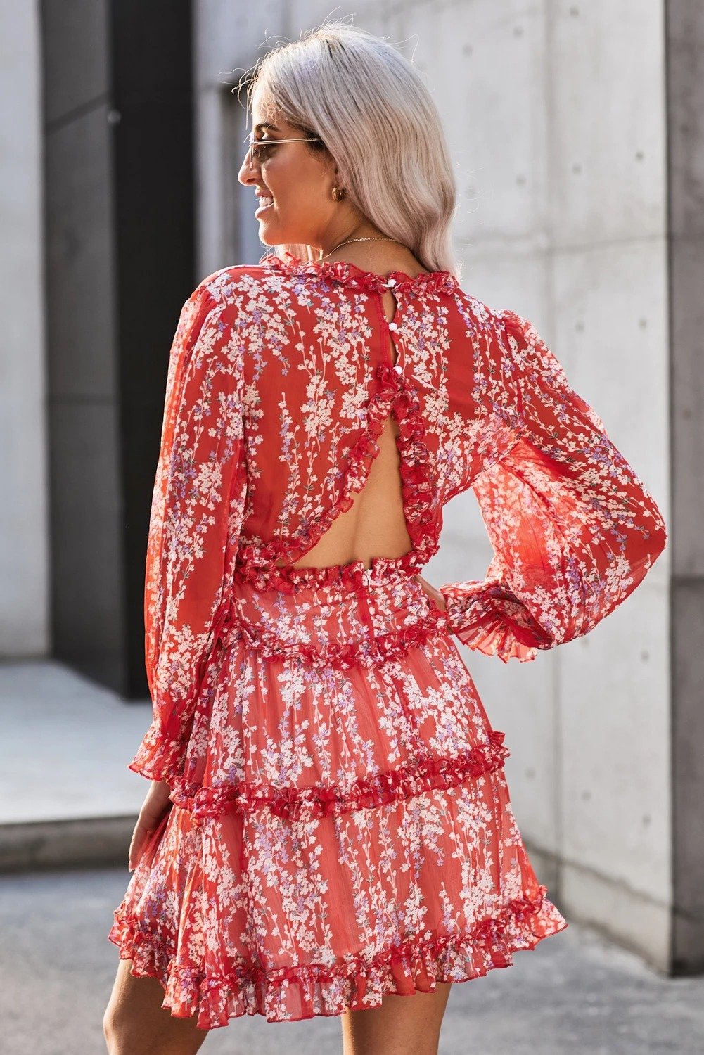 A vibrant red floral dress featuring ruffle detailing, long sleeves, and an open back design, perfect for spring and autumn occasions.