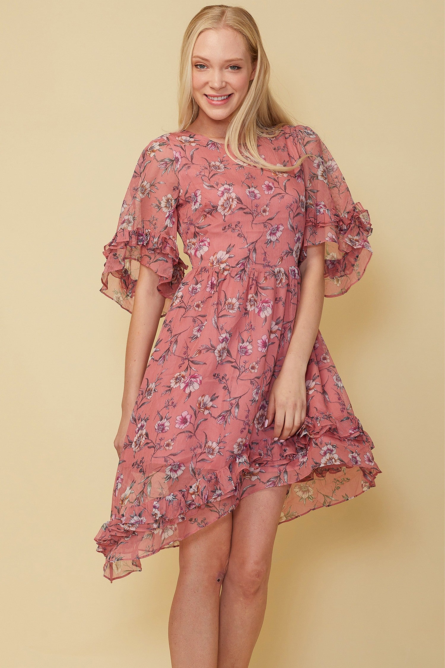 A stylish Wax Flower Asymmetrical Hi-Lo Dress featuring a sheer floral print, ruffle hem, and open back design.