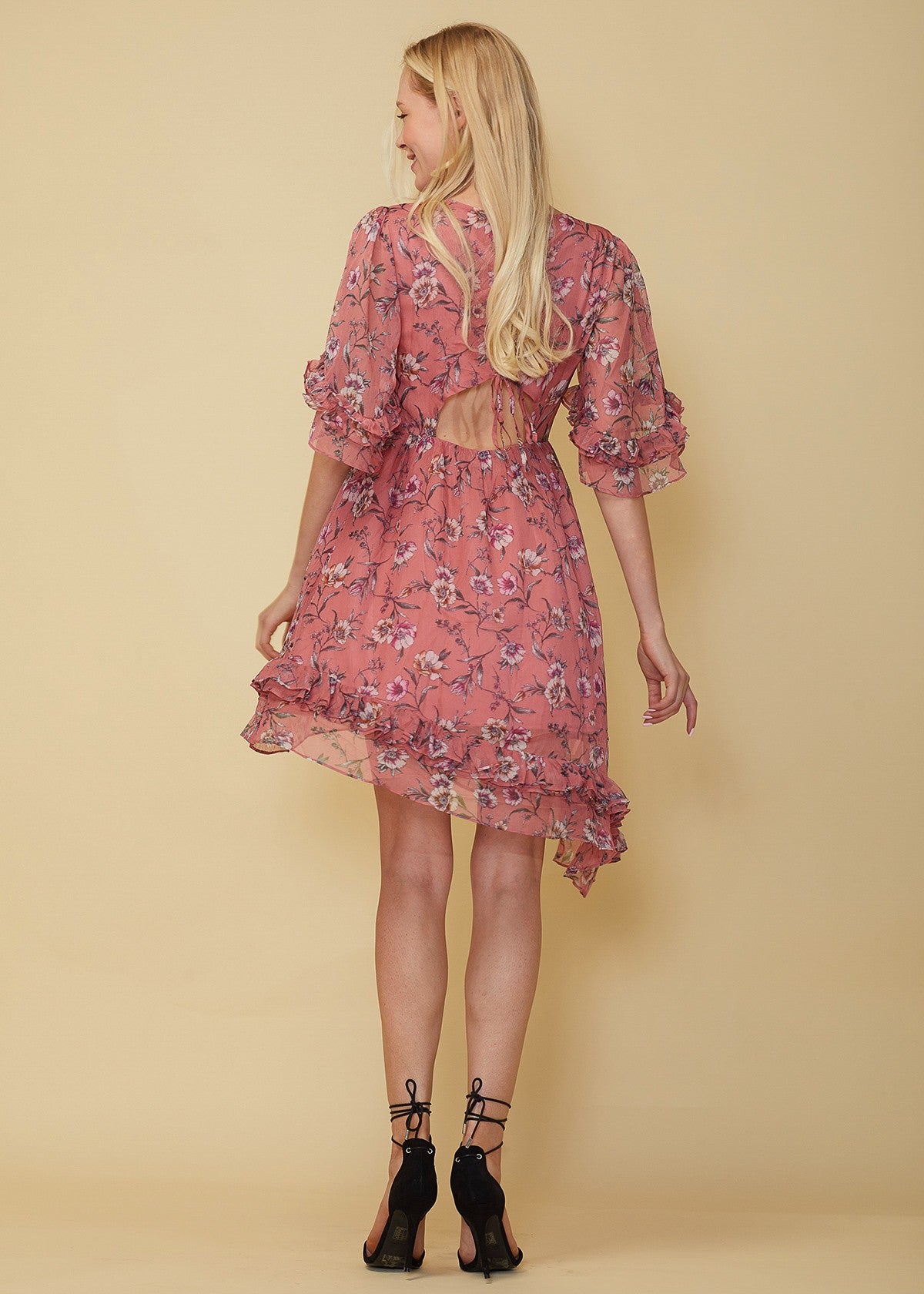 A stylish Wax Flower Asymmetrical Hi-Lo Dress featuring a sheer floral print, ruffle hem, and open back design.