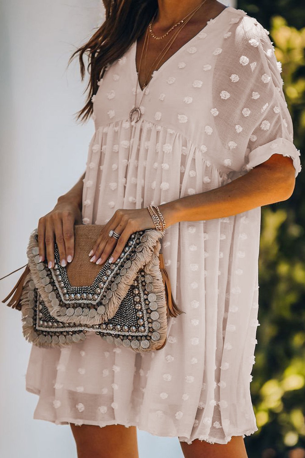 Woman in white dress holding clutch.