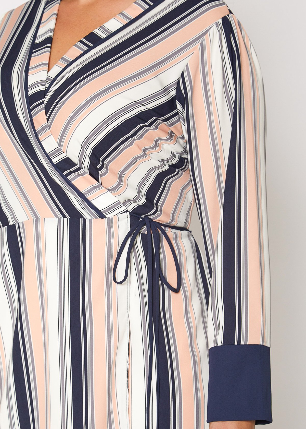 Women's multi-stripe printed wrap dress with cuff binding and waist tie detail, showcasing long sleeves and vibrant colors.