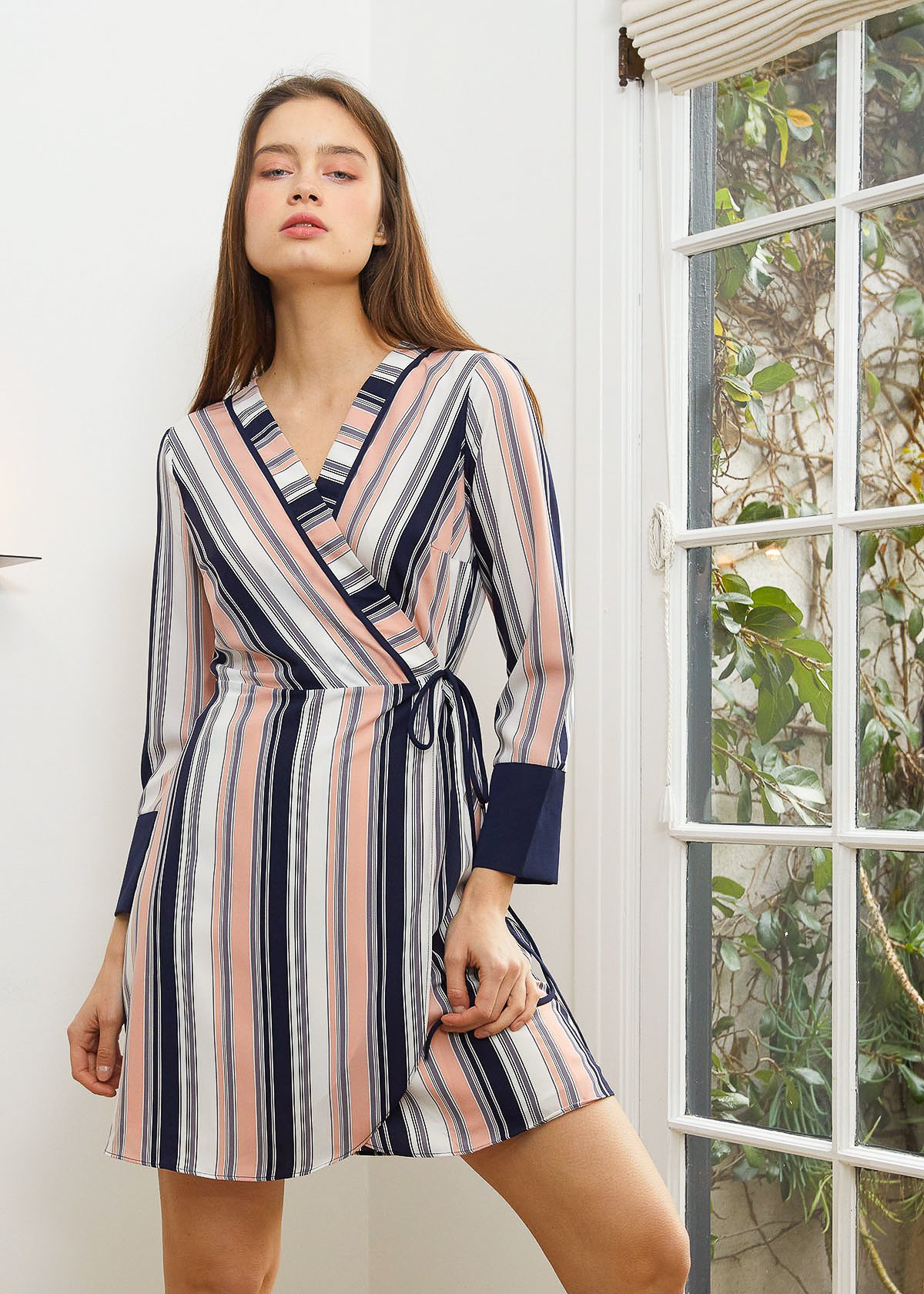 Women's multi-stripe printed wrap dress with cuff binding and waist tie detail, showcasing long sleeves and vibrant colors.