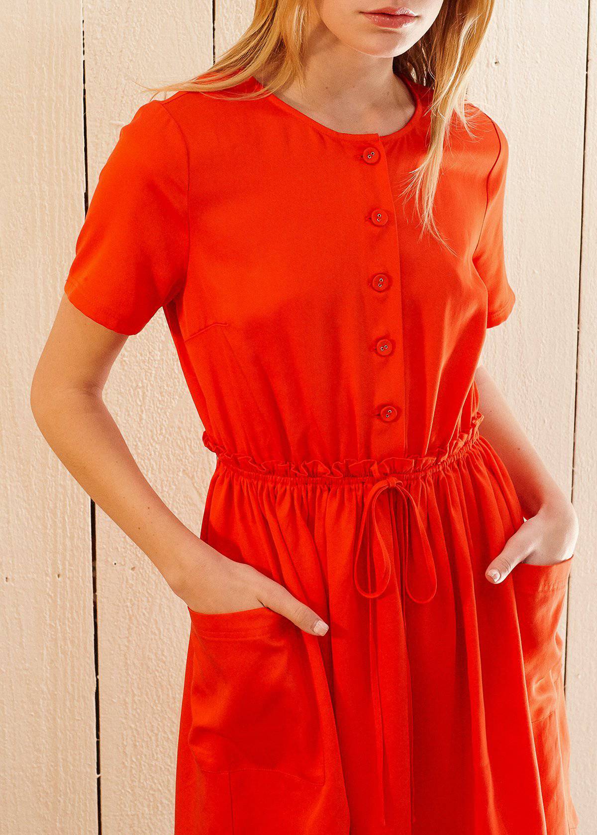 Women's Short Sleeve Utility Dress in vibrant Poppy color, featuring two side pockets and an elastic waist for a comfortable fit.