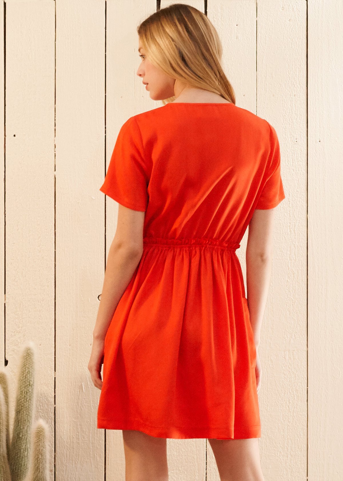 Women's Short Sleeve Utility Dress in vibrant Poppy color, featuring two side pockets and an elastic waist for a comfortable fit.