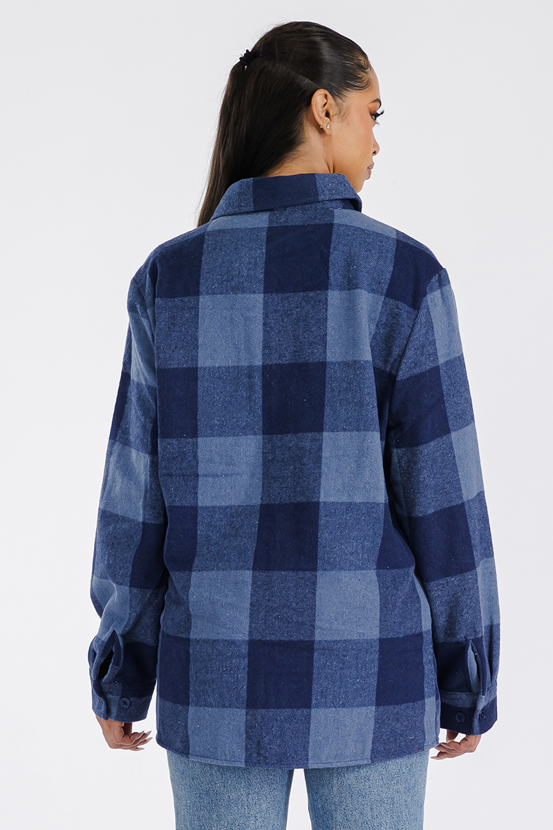 A stylish woman wearing a Boyfriend Oversized Soft Flannel Shacket, showcasing its soft fabric, button closure, and chest pockets.