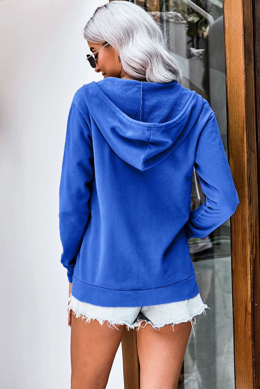 Casual blue zip-up hoodie jacket with white metallic zipper and drawcords, showcasing a stylish and comfortable design for various occasions.