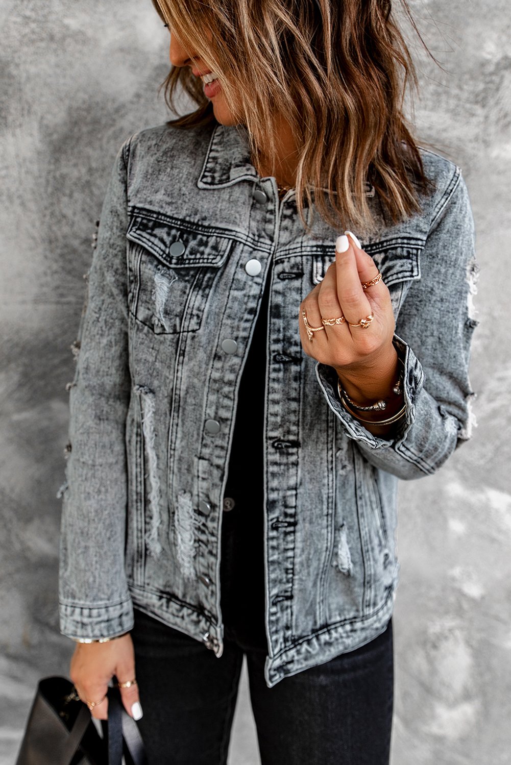 Gray distressed jean jacket featuring a turn-down collar and button closure, perfect for casual winter wear.