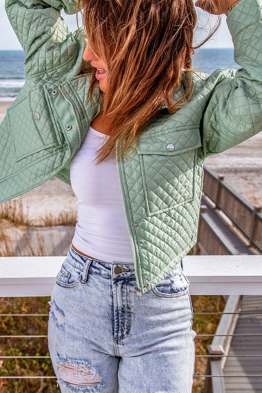 A stylish green quilted cropped jacket with a zip-up front and chic pockets, perfect for winter fashion.