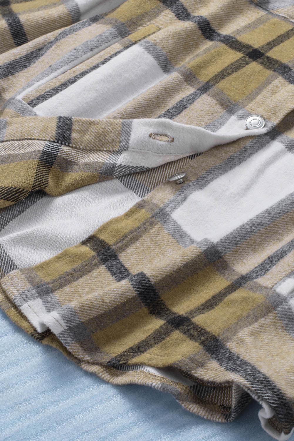 Khaki button-up pocket plaid shacket displayed on a mannequin, featuring a stylish plaid pattern and front pockets.