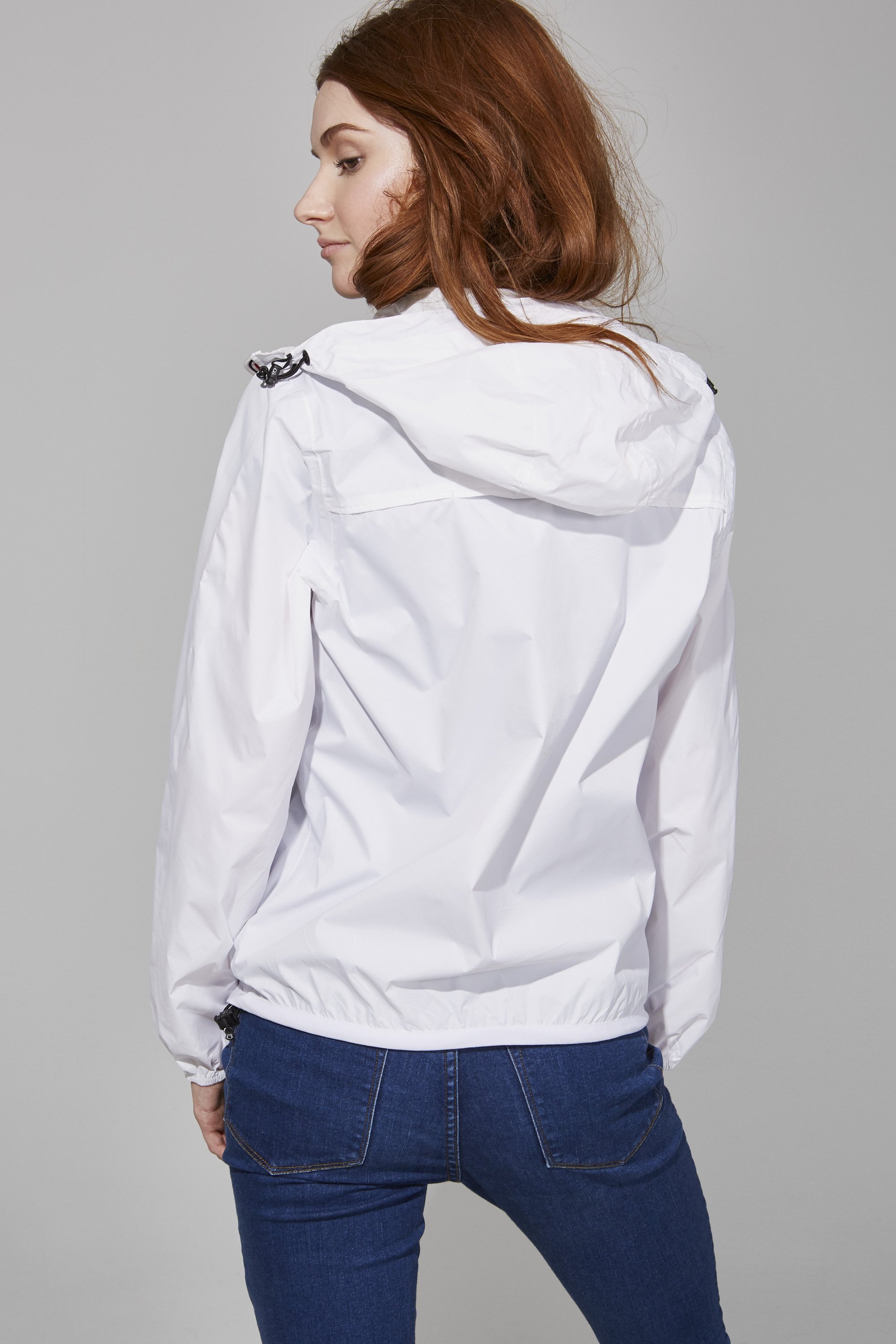 White Full Zip Packable Rain Jacket displayed on a mannequin, showcasing its ergonomic hood, custom zipper, and hidden side pockets.