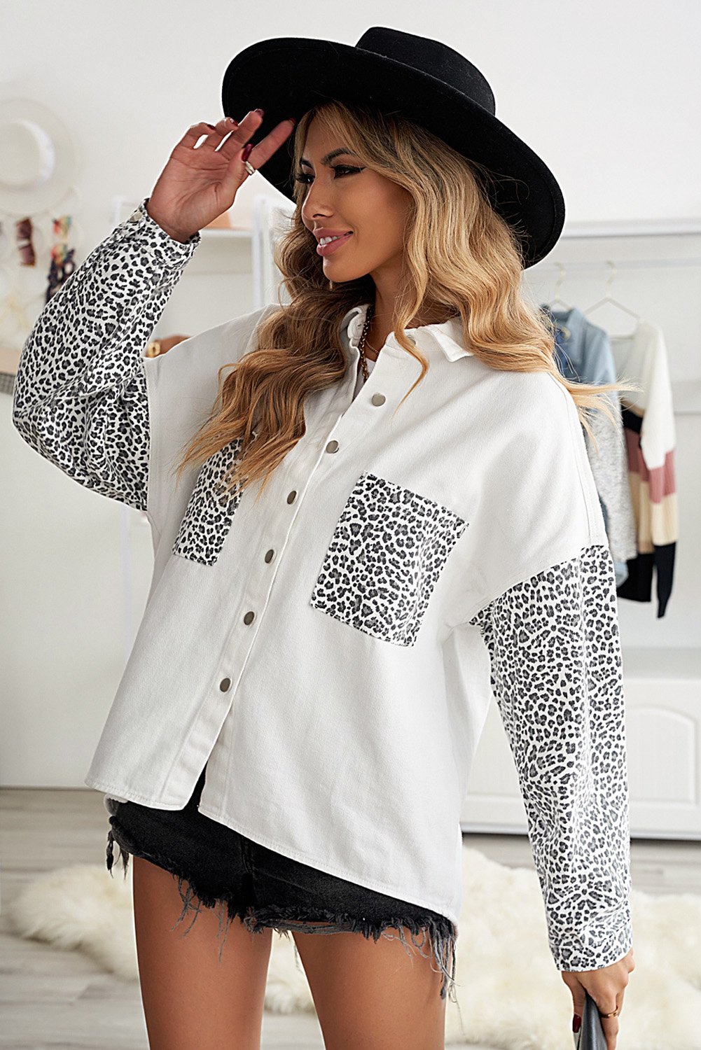 White denim shirt jacket with leopard print sleeves, featuring front snap closures and pockets.