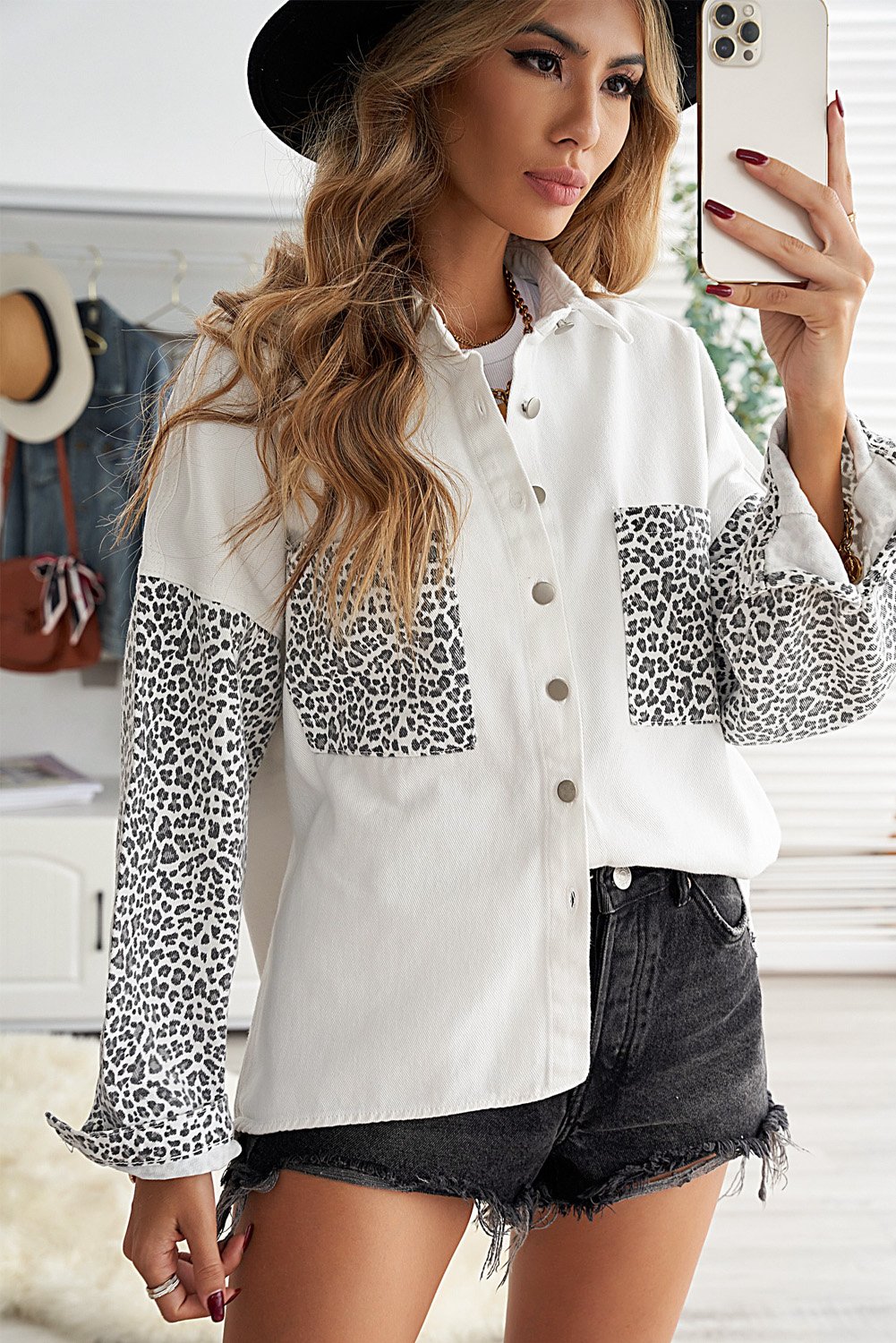 White denim shirt jacket with leopard print sleeves, featuring front snap closures and pockets.