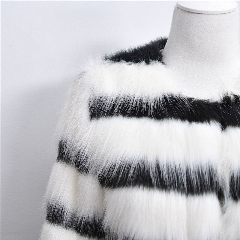 Elegant women's winter coat featuring black and white stripes made of soft faux fur, designed for warmth and style.